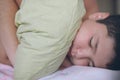 Healthy fat small caucasian kid hugging green cushion lying deep sleeping in morning