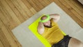 Fat tired man in yellow sportswear doing abs exercise crunches lying on mat.