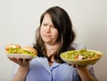 Fat white woman having choice between hamburger and salad close up, unhealth fast food