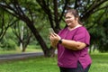 Fat woman asian holding smart phone with listening to music.