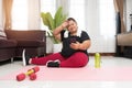 Fat woman asian take a break exercising with using smart phone at home Royalty Free Stock Photo