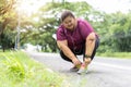 Fat woman asian tying shoelaces outdoors and get ready to run,