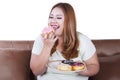 Fat woman eats donut on plate Royalty Free Stock Photo