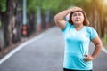 Fat woman feeling tired while running in the park