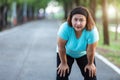 Fat woman feeling tired while running in the park