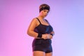 Fat woman in gym. Body positive and fitness concept. Girl is upset about being overweight and belly fat.