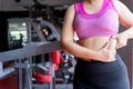 Fat woman holding excessive fat belly lower back, overweight fatty belly at fitness gym. Diet lifestyle, weight loss, stomach Royalty Free Stock Photo