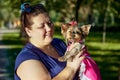 Fat woman holds terrier in park during walking. Royalty Free Stock Photo