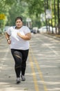 Fat woman jogging on the road Royalty Free Stock Photo