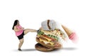 Fat woman kicking tasty foods on studio Royalty Free Stock Photo