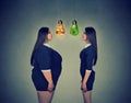 Fat woman looking at happy slim fit girl. Diet choice concept Royalty Free Stock Photo