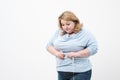 A fat woman measures her waist with a measuring tape in casual clothing on a white background. Royalty Free Stock Photo