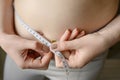 A fat woman measures her waist with a measuring tape, close-up.Lifestyle, diet concept. Royalty Free Stock Photo