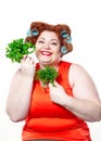 Fat woman with sensuality red lipstick in curlers on a diet holding parsley and dill Royalty Free Stock Photo