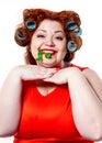 Fat woman with sensuality red lipstick in curlers on a diet holding parsley and dill Royalty Free Stock Photo