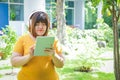 Fat women turn on tablets, wear headphones, listen to music in the garden.