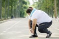 Fat woman tying her shoelaces on the road