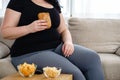Fat woman watching series at tv eating junk food
