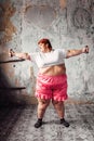 Fat woman on workout with dumbbells, obesity