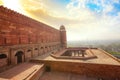 Fatehpur Sikri fort wall made of red sandstone with aerial view of cityscape at sunrise at Agra, India