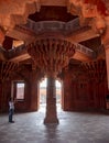 FATEPHUR SIKRI, INDIA- MARCH, 27, 2019: visitor photographs the famous carved stone column of the diwan-i-khas palace