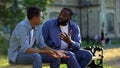 Father arguing teenage son sitting on campus bench, puberty age difficulties Royalty Free Stock Photo