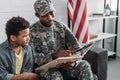 Father in army uniform and african american boy