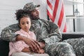 Father in army uniform hugging african american