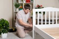 The father assembles the children& x27;s bed for the child, the man twists the screws into wooden furniture. Royalty Free Stock Photo