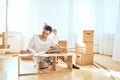 Father assembling furniture in living room of new apartment, mother with son and pile of moving boxes on background Royalty Free Stock Photo
