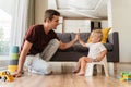 Father assisting his little boy sitting on pot in potty training giving high five to his dad Royalty Free Stock Photo