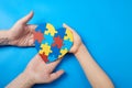 Father and autistic son hands holding jigsaw puzzle heart shape. Autism spectrum disorder family support concept. World Royalty Free Stock Photo