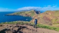 Sao Lourenco - Father with baby carrier looking at majestic Atlantic Ocean coastline at Ponta de Sao Lourenco peninsula