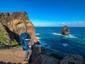 Sao Lourenco - Father with baby carrier looking at majestic Atlantic Ocean coastline at Ponta de Sao Lourenco peninsula