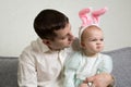 Dad and baby with hare ears, the girl is wrinkling her nose