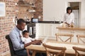 Father And Baby Daughter Use Laptop As Mother Prepares Meal Royalty Free Stock Photo