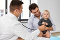 Father with baby and doctor at clinic