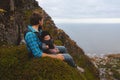 Father with baby family travel vacations man dad hiking with child sitting on mountain top