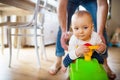 Father with a baby girl sitting on a toy car at home. Royalty Free Stock Photo