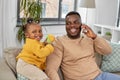 Father with baby at home calling on smartphone Royalty Free Stock Photo