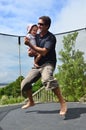 Father and baby Jumping on trampoline Royalty Free Stock Photo