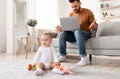 Father With Baby Working On Laptop Having Problems At Home Royalty Free Stock Photo