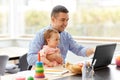 Father with baby working on laptop at home office Royalty Free Stock Photo
