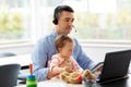 Father with baby working on laptop at home office Royalty Free Stock Photo