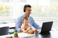 Father with baby working on laptop at home office Royalty Free Stock Photo