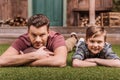 Father with ball and little son laying on the grass at backyard Royalty Free Stock Photo