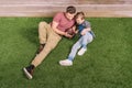 Father with ball and little son laying on the grass at backyard Royalty Free Stock Photo