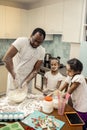 Father beating whites while cooking pie with his daughters