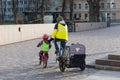 Father with bike stroller and children cycling in the city