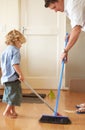 Father with boy kid sweep up mess, family cleaning together and help with broom and dustpan. Hygiene, chores and house